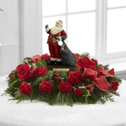 Norman Rockwell Drum for Tommy Figurine in the Center of a centrepiece featuring Fir, Pine, Holly, Roses and Carnations.  